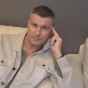 Мужчина в светлой рубашке сидит на диване